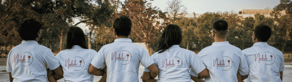 This photo shows a group of Naksh Foundation volunteers wearing official T-shirts, displaying the organization’s logo.